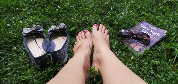 芝生で休憩する素足の綺麗な女性