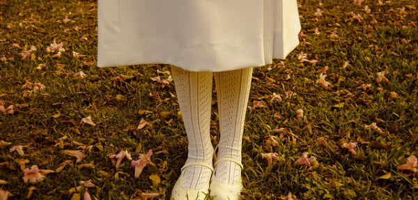 紅葉の森に佇む白いスカートの女性